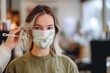 © alisaaa - young woman with a face mask in a hair salon dying hair after covid-19 quarantine