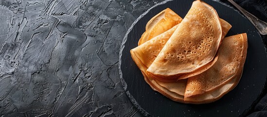 Poster - Tasty thin pancakes served on a sleek slate plate with copy space image