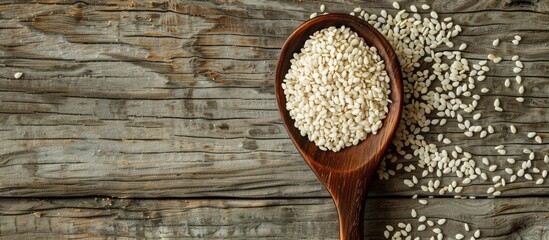 Poster - Wooden spoon with white sesame seeds on rustic wood background with copy space image