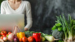 © mahamad - Online shopping for fresh vegetables, with a woman using a computer representing a lifestyle concept. Copy space available for adding text or design.