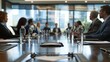 © Matthew - A group of professionals engaged in a business meeting, seated around a large conference table in a modern office, with documents and water bottles present.