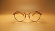© Aris Suwanmalee - A pair of round, gold-rimmed eyeglasses with clear lenses on a beige background.