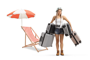 Wall Mural - Young female tourist holding many suitcases next to a beach chair