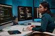© Mediaphotos - Side view portrait of female computer programmer typing at keyboard and writing code at office workplace copy space