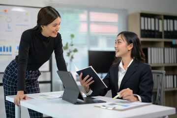 Aufkleber - Professional Business Meeting Between Two Women in Modern Office Setting with Documents and Digital Devices
