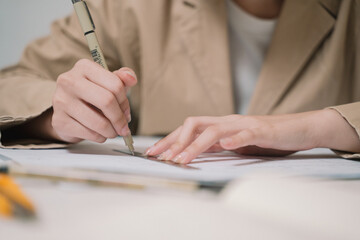 The architect carefully sketches a detailed design drawing by hand, shaping the blueprint for a significant architecture project, blending business acumen with engineering precision.