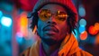 © VISUAL BACKGROUND - A man wearing a beanie and sunglasses in front of a city street at night