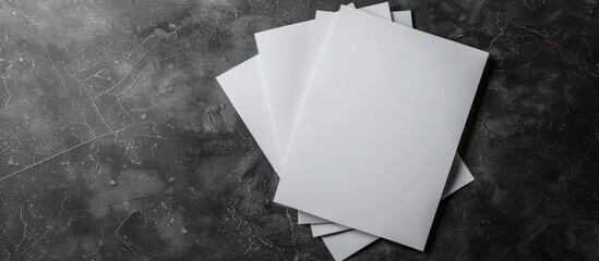 Wall Mural - Top view of blank paper sheets on a dark textured background for design mockup with copy space image