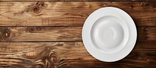 Wall Mural - Top view of a white ceramic plate on wooden table with copy space image