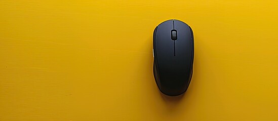 Fototapete - Copy space image of a black wireless mouse on a yellow surface seen from above