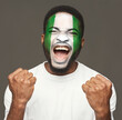 © Prostock-studio - Face of young screaming african-american man painted with flag of Nigeria. Football or soccer team fan, sport event, faceart and patriotism concept. Studio shot at gray background, copy space