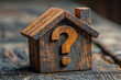 © Gonzalo - Wooden house models with a question mark, symbolizing uncertainty in real estate or home buying decisions