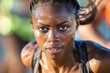 © spyrakot - Focused Female Marathon Runner Mid Stride with Intense Expression and Sweat in Sunlight