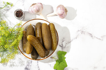 Wall Mural - Fresh pickled cucumbers in a bowl with garlic and dill on a concrete table, village harvest, homemade pickling recipe, cucumbers and ingredients for pickling,