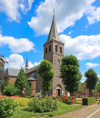 Kinrooi (Geistingen, Sint-Lambertuskerk), Belgium - July 9. 2024: Beautiful medieval church with blooming summer garden in belgian village