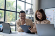 © Wasana - Two people are sitting at a desk with a white board behind them
