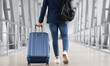© Prostock-studio - Unrecognizable Man With Bag And Suitcase Walking In Airport Terminal, Rear View Of Young Male On His Way To Flight Boarding Gate, Ready For Business Travel Or Vacation Journey, Cropped, Copy Space