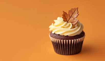 Autumn Fall Leaves Cupcake on an Orange Background with Space for Copy