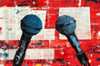 © sergign - Two blue and black microphones stand against a vivid red abstract background, symbolizing communication and artistic expression in a striking visual.