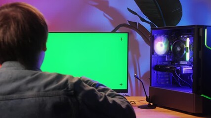 Computer with chroma key green screen on monitor. Gamer man playing in popular video games. Programmer or hacker coding a code and working in networks, cyberspace. Digital software, mobile app