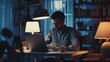 © vefimov - A male using his laptop computer in a dimly lit room.