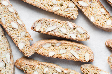 Wall Mural - almond biscotti on white parchment lined tray, almond cantucci cookies on a white board, flatlay of slices of biscotti cookies or twice baked cookies