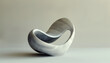 © Steven - A modern, abstract marble sculpture with smooth curves and a loop design, set against a plain beige background.