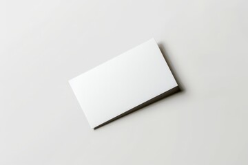 Aufkleber - A white business card is positioned slightly tilted on a neutral surface, providing a simple and sophisticated look with focus on readiness for branding and customization.