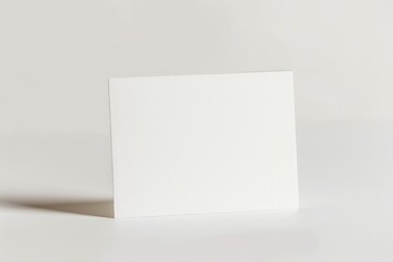 Leinwandbilder - A blank white card standing upright on a light gray surface. The image encapsulates ideas of cleanliness and minimalism with no text or graphical elements present.