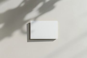Leinwandbilder - A small white rectangular object casting a shadow on a white surface with visible soft shadows of surrounding elements. The image signifies calm and tranquility.