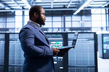 Poster - software developer walking in data center, using laptop to configure network infrastructure such as 