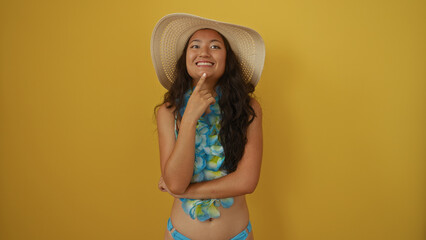 Wall Mural - Beautiful chinese woman in swimsuit and hat posing against yellow background