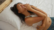 © Krakenimages.com - Beautiful young asian woman laughing on the bed in a cozy bedroom at home