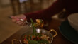 © Krakenimages.com - A young woman enjoys a beautifully presented italian meal at a cozy restaurant, savoring a mouthful of fresh cuisine.