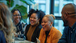 © Chatchanan - Diverse office team laughing and talking during a productive meeting, creating a positive work environment