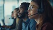 © Oulailux - A group of people are working in an office, with one woman wearing a headset