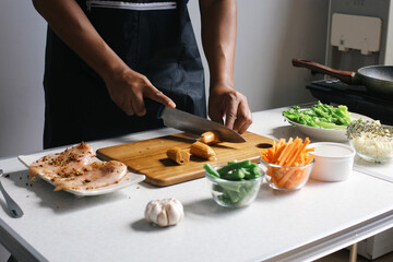 Hands Cutting Sausage With Knife On Wooden Board. Preparing Making Chicken Steak Homemade