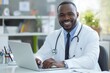 © FACTORY GRAPHICA  - smiling  african american doctor work with laptop on hospital office