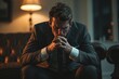 © Boomanoid - Stressed Businessman in Suit Sitting on Couch in Dimly Lit Room