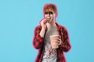 Poster - Young man dressed for Halloween eating popcorn on light blue background