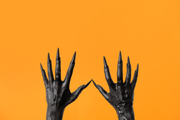 Sticker - Black hands of witch on orange background. Halloween celebration