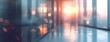 © Pasha Studio - Blurred hallway or corridor with glass walls and reflective floor Warm sunset light creating atmospheric glow in modern interior