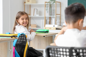 Sticker - Little school girl in classroom during lesson