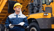 © Parilov - Concept banner automated logistics online internet. Dump truck driver man in uniform with tablet computer controls loading of cargo or coal.