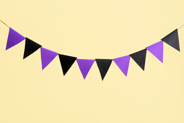 Wall Mural - Garland made of paper flags for Halloween celebration on beige background