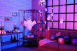 © Pixel-Shot - Interior of dark living room with Halloween decor and shelf units