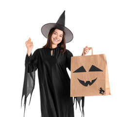 Wall Mural - Young woman dressed for Halloween as witch with gift bag on white background