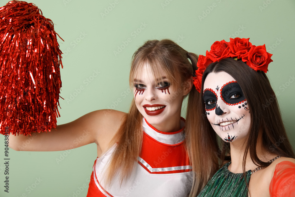 Female friends dressed for Halloween on green background, closeup