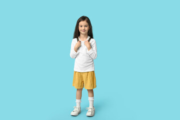 Cute little girl in stylish clothes on blue background