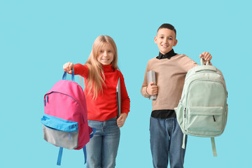 Wall Mural - Cute pupils with backpacks, laptop and book on blue background